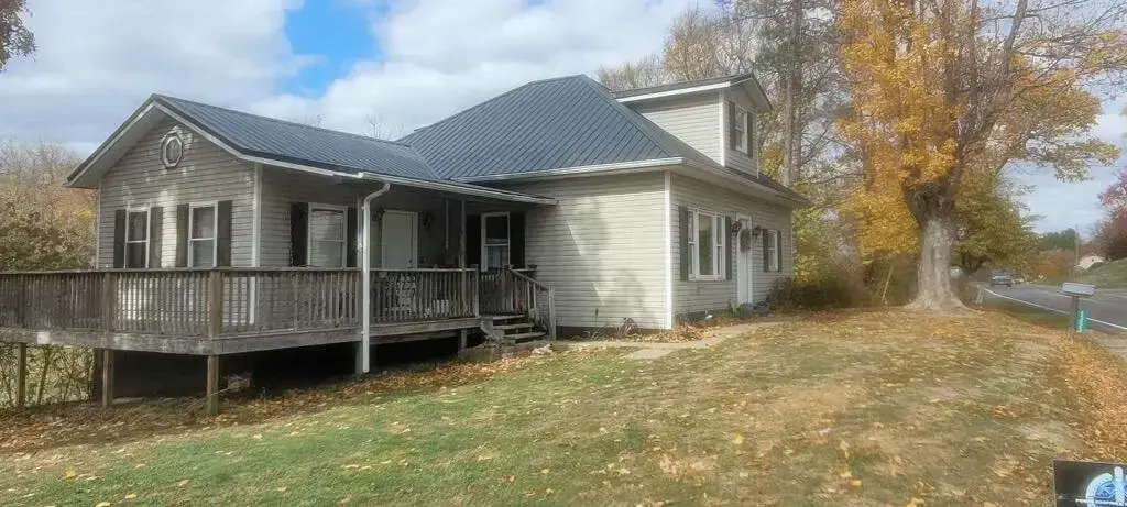 Older Ohio farmhouse with a new dark metal roof replacing worn asphalt shingles